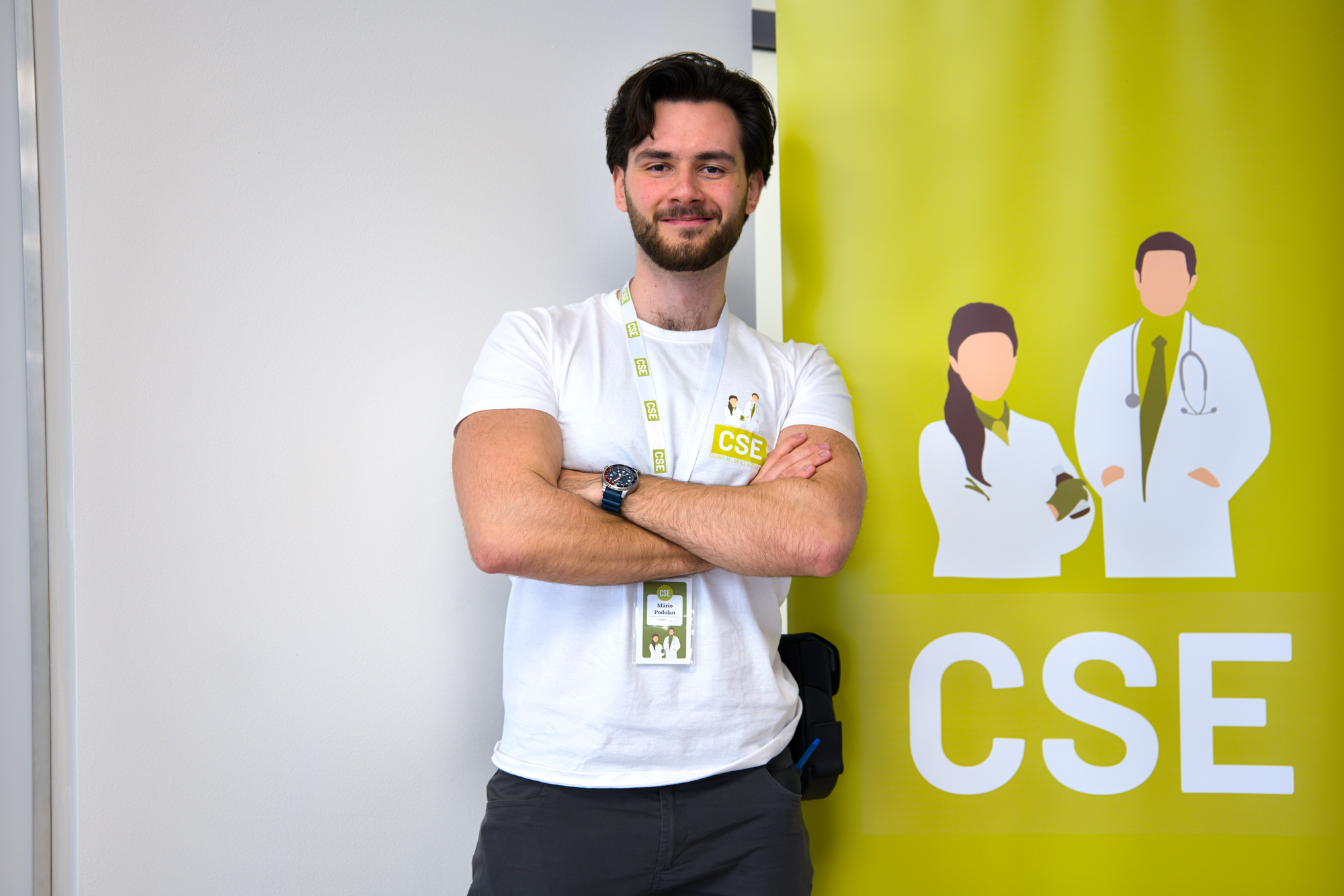Mário Podolan so skríženými rukami pred žltým bannerom CSE